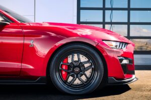 Side view of a sleek red sports car featuring distinctive Cobra logo, vibrant brake calipers, and modern alloy wheels. That was recently detailed by Ethans Mobile Detailing in SoCal